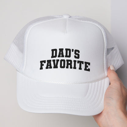 a person holding a white hat that says dad&#39;s favorite
