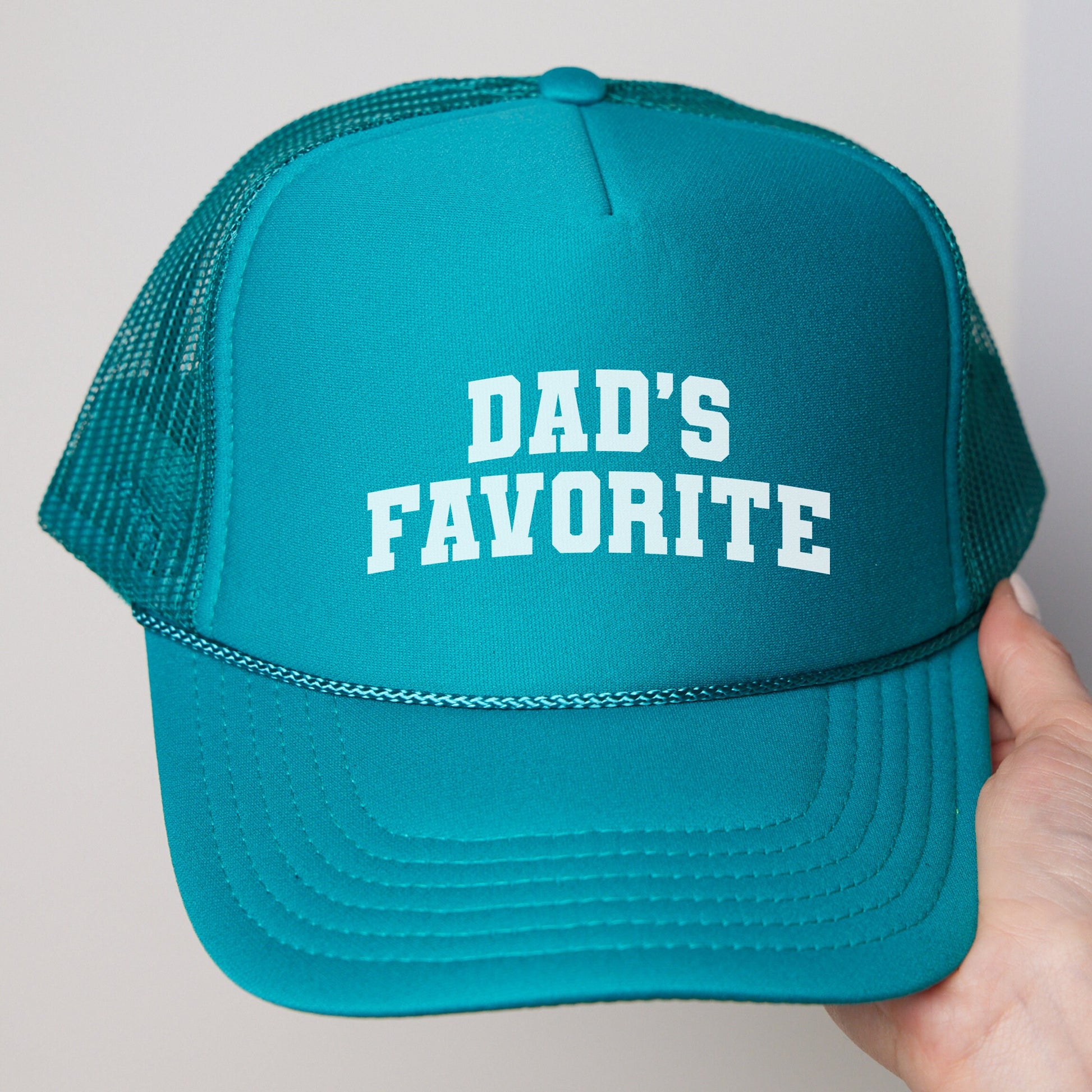 a person holding a hat that says dad&#39;s favorite