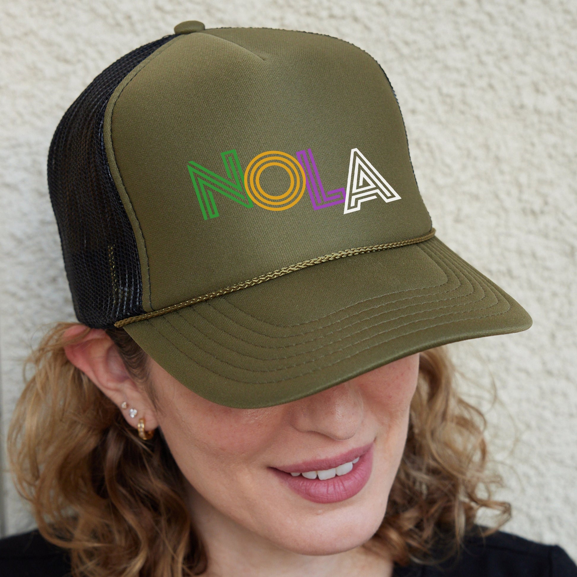 a woman wearing a trucker hat with the word aloh on it