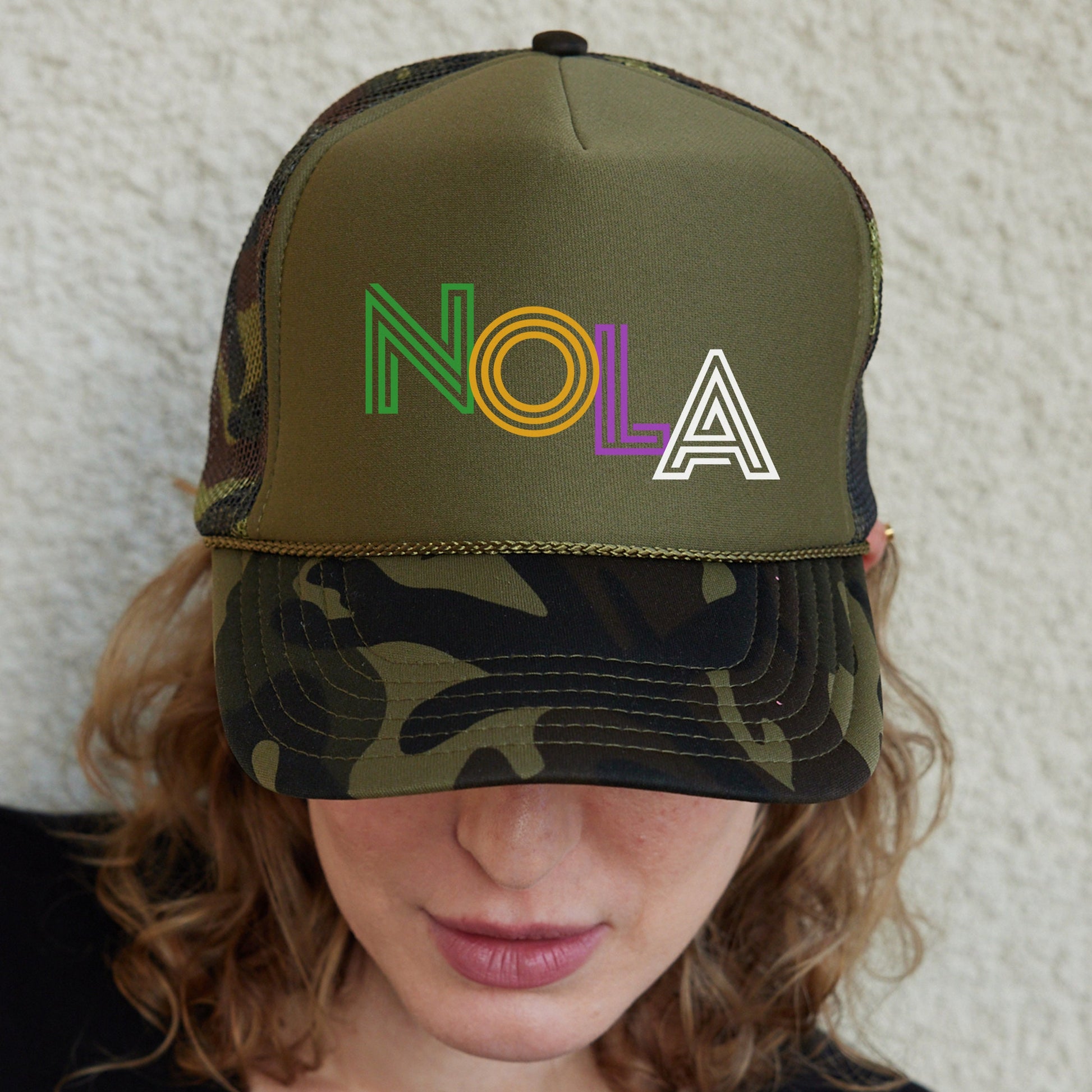 a woman wearing a hat with the word nola on it