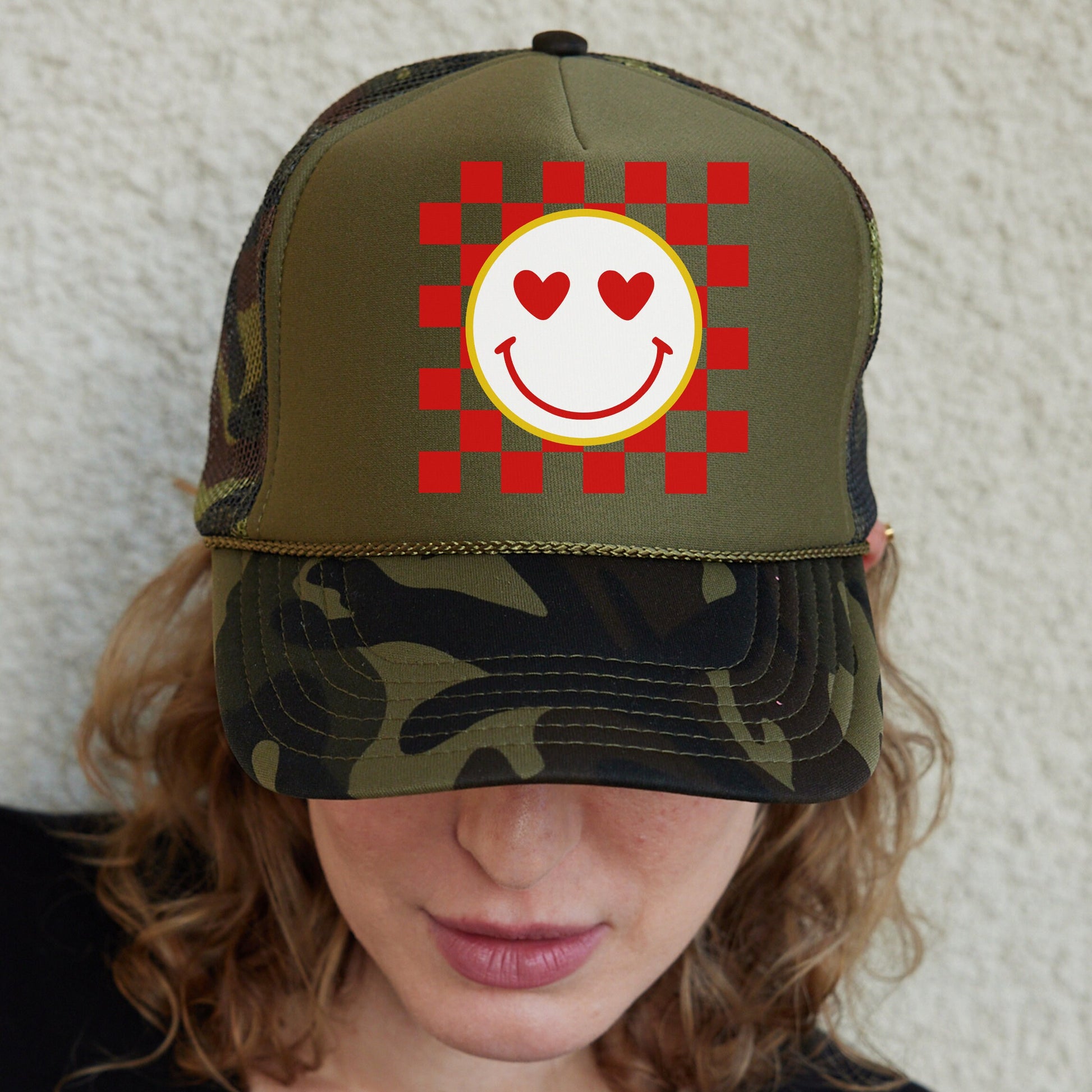 a woman wearing a hat with a smiley face on it