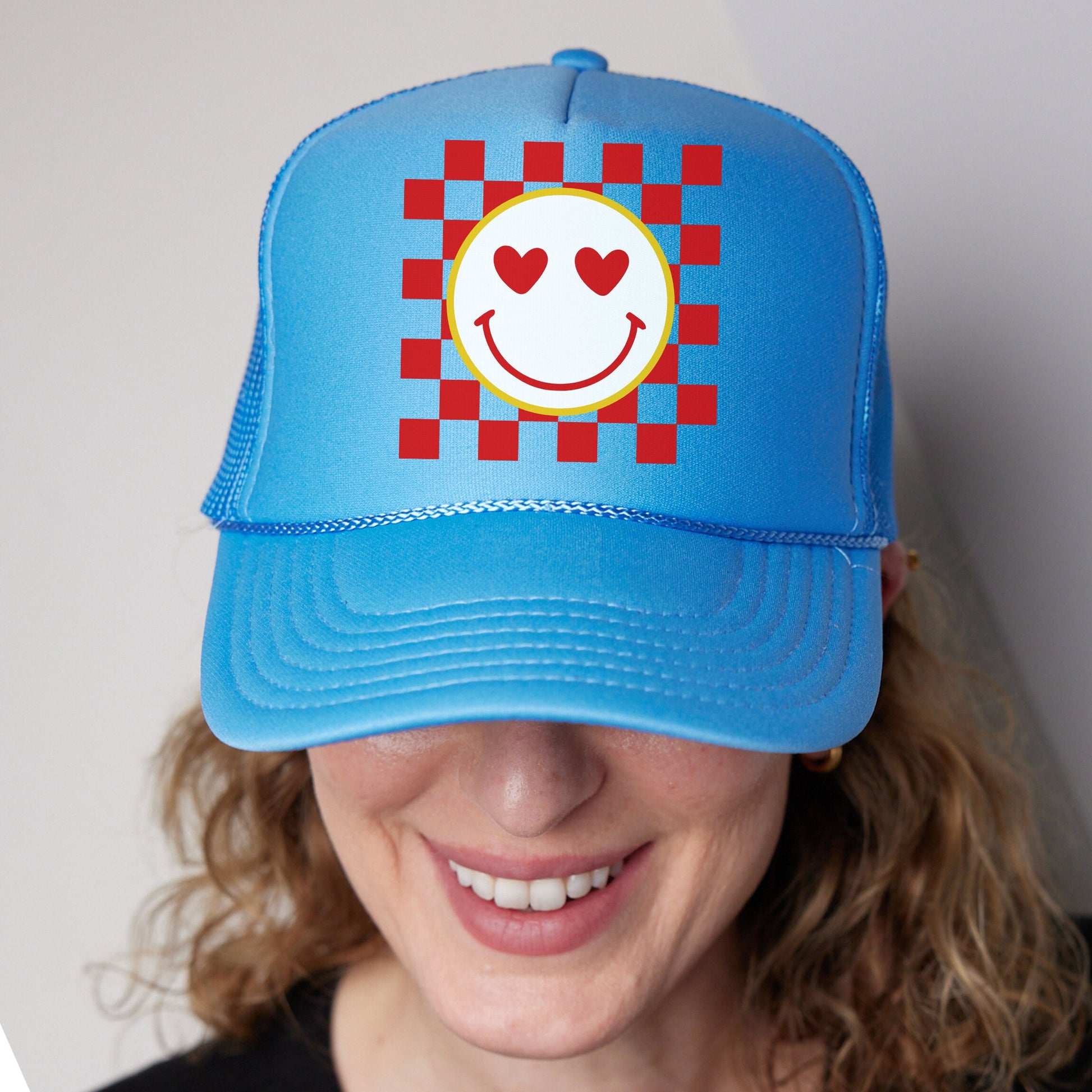 a woman wearing a blue hat with a smiley face on it