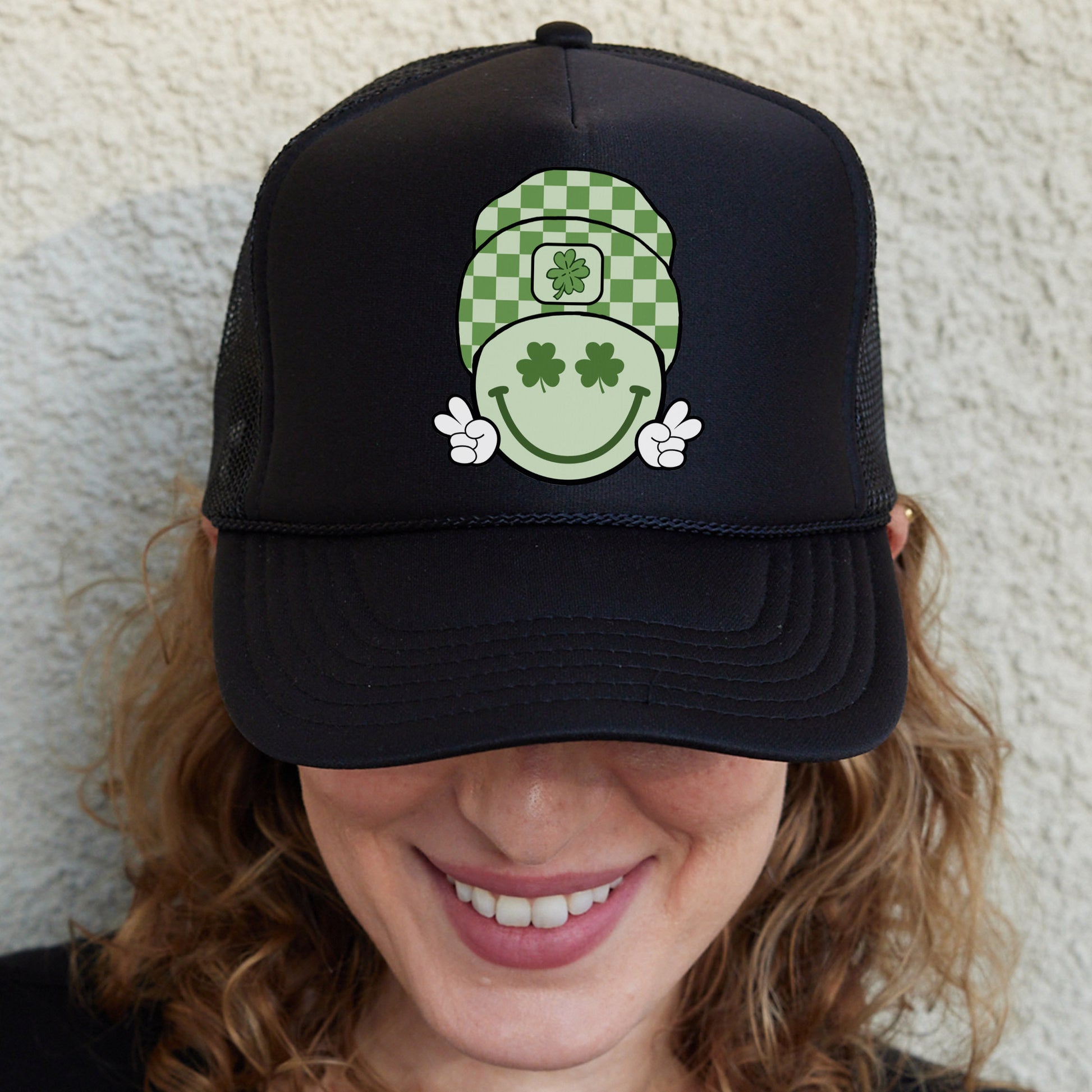 a woman wearing a black hat with a green and white design on it