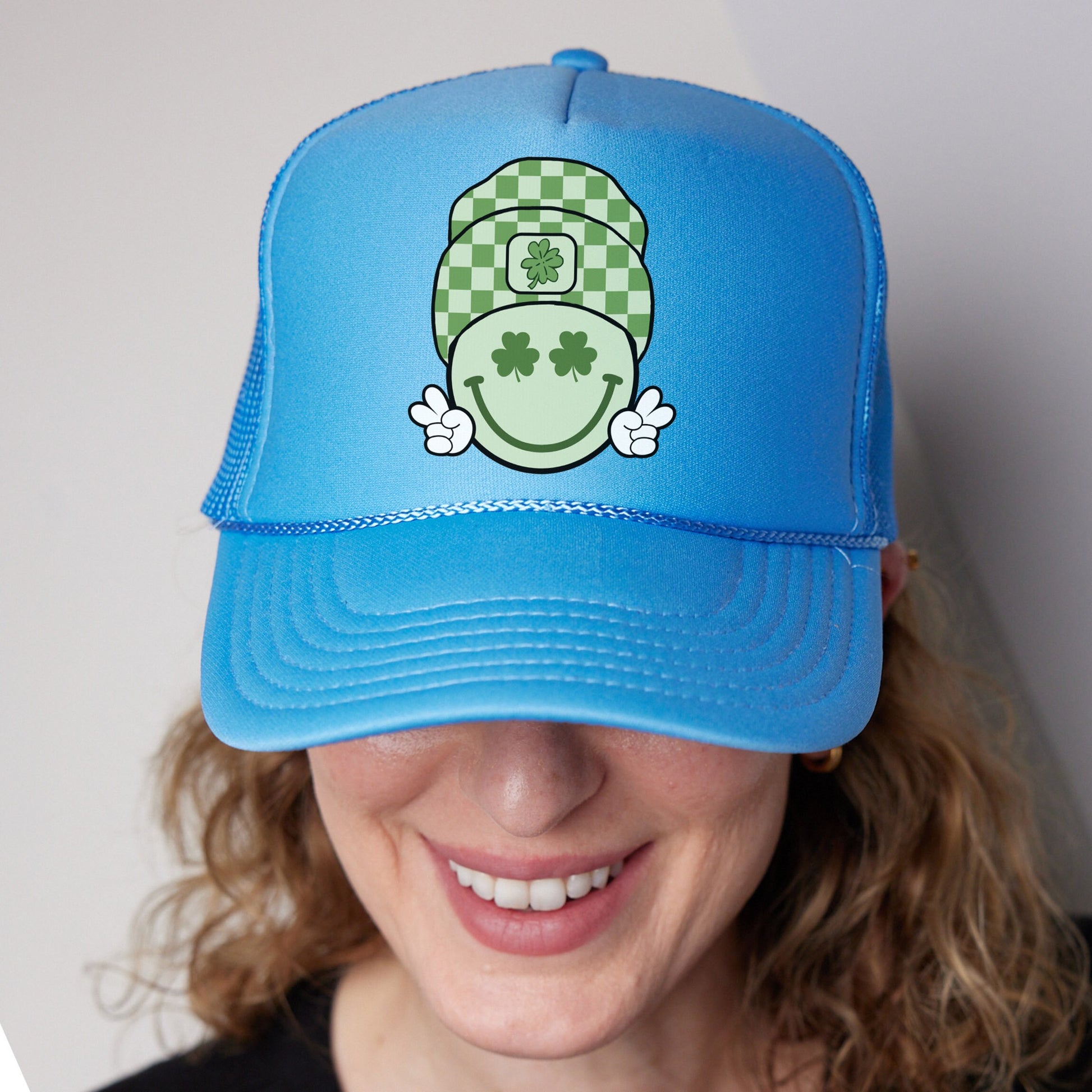 a woman wearing a blue hat with a green smiley face