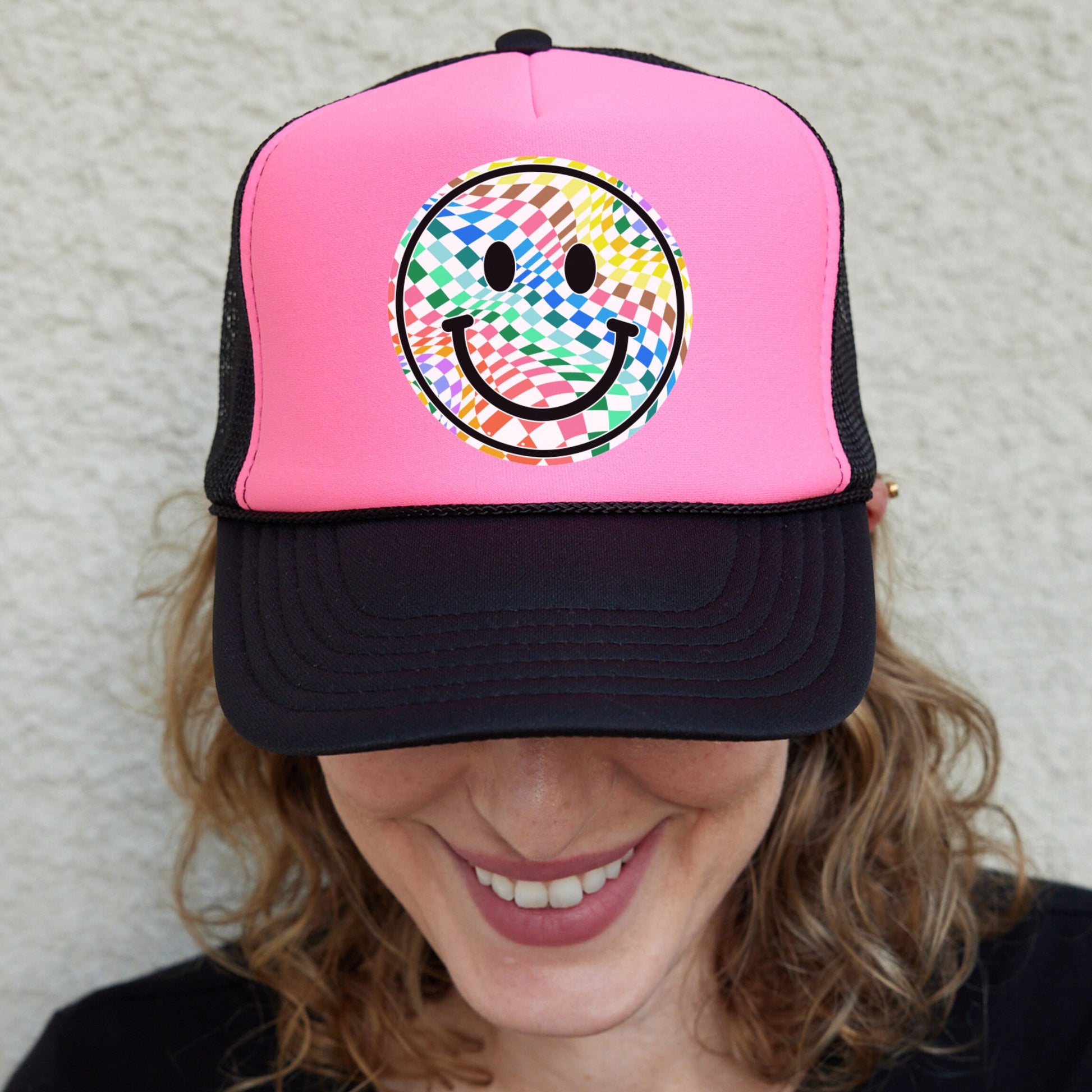 a woman wearing a pink hat with a smiley face on it