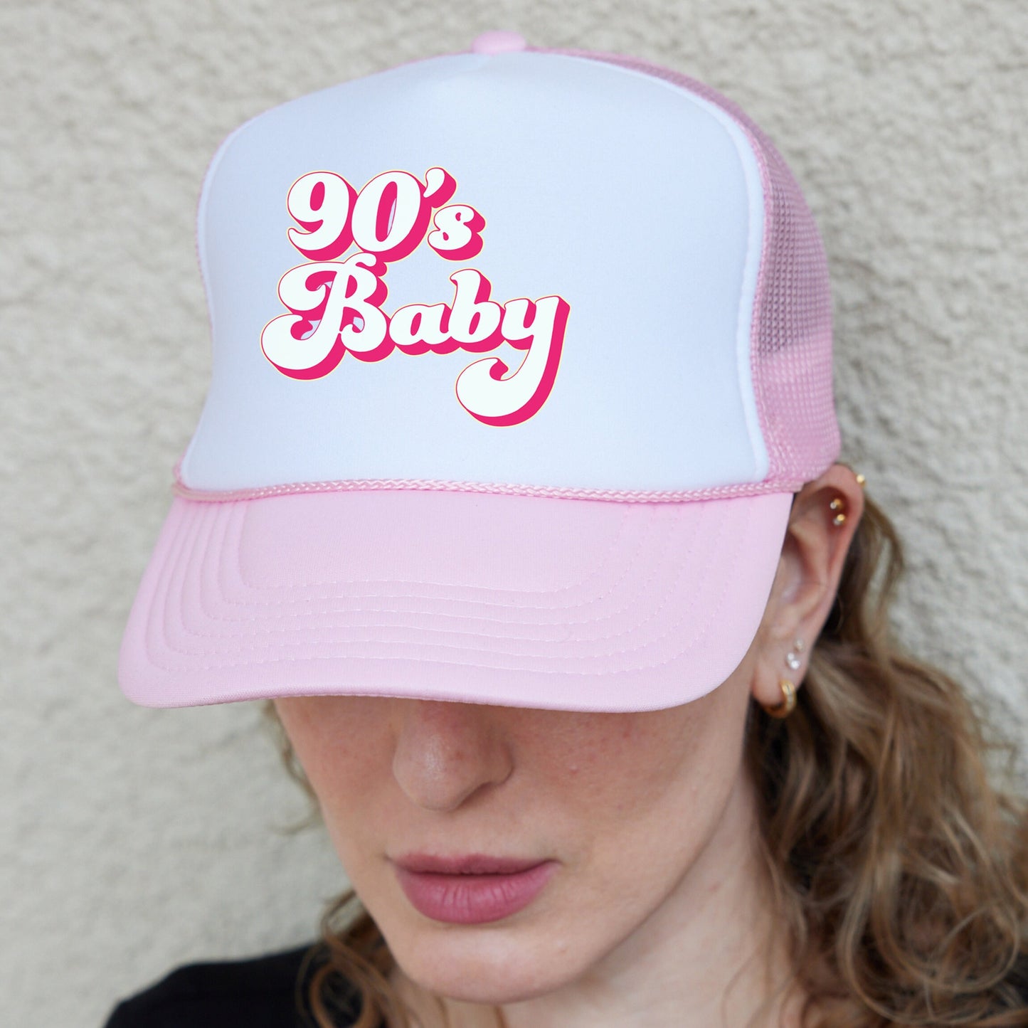 a woman wearing a pink and white 90&#39;s baby hat
