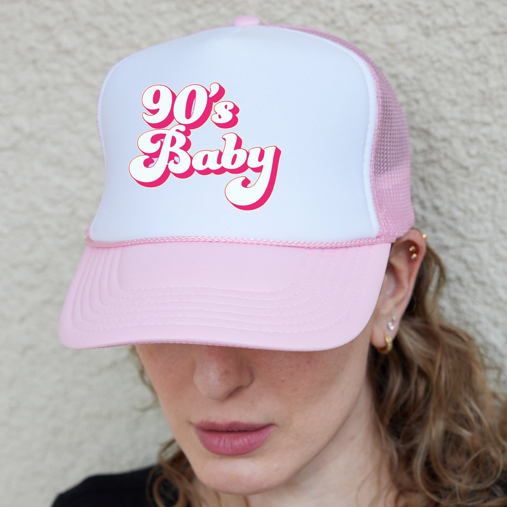 a woman wearing a pink and white 90&#39;s baby hat
