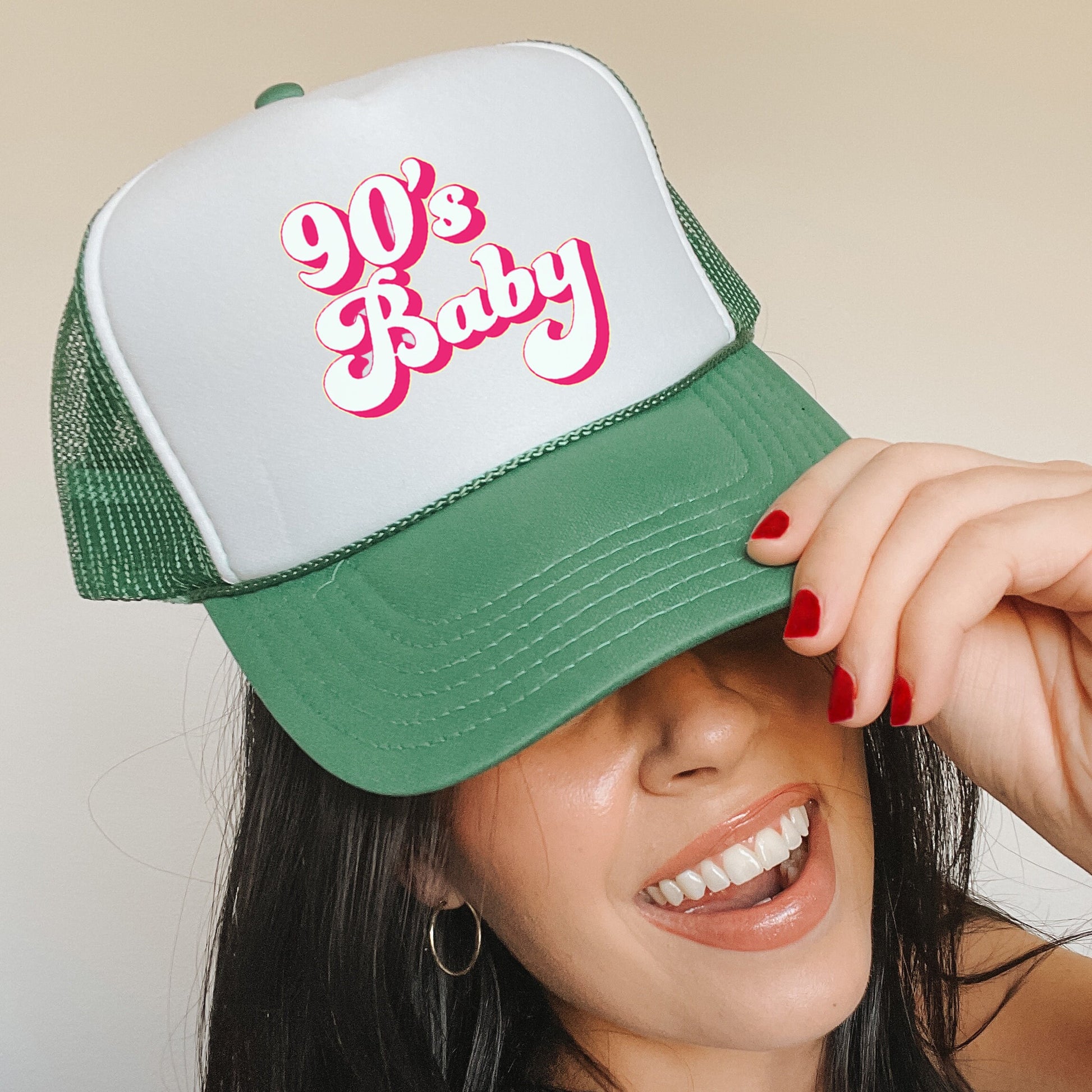 a woman wearing a green and white 90&#39;s baby hat