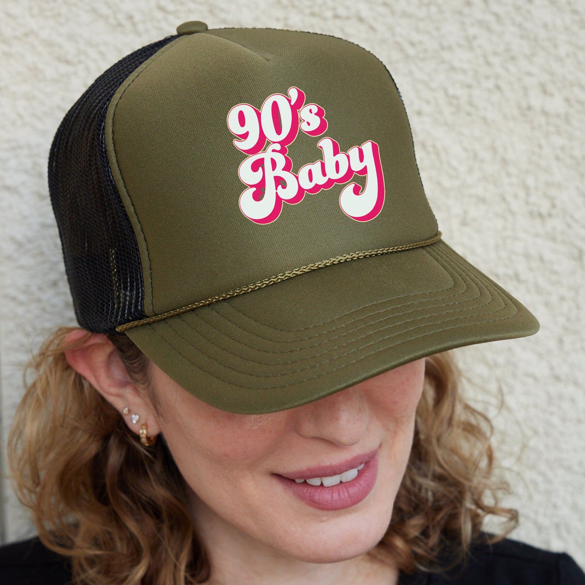 a woman wearing a trucker hat with the word 90&#39;s baby on it