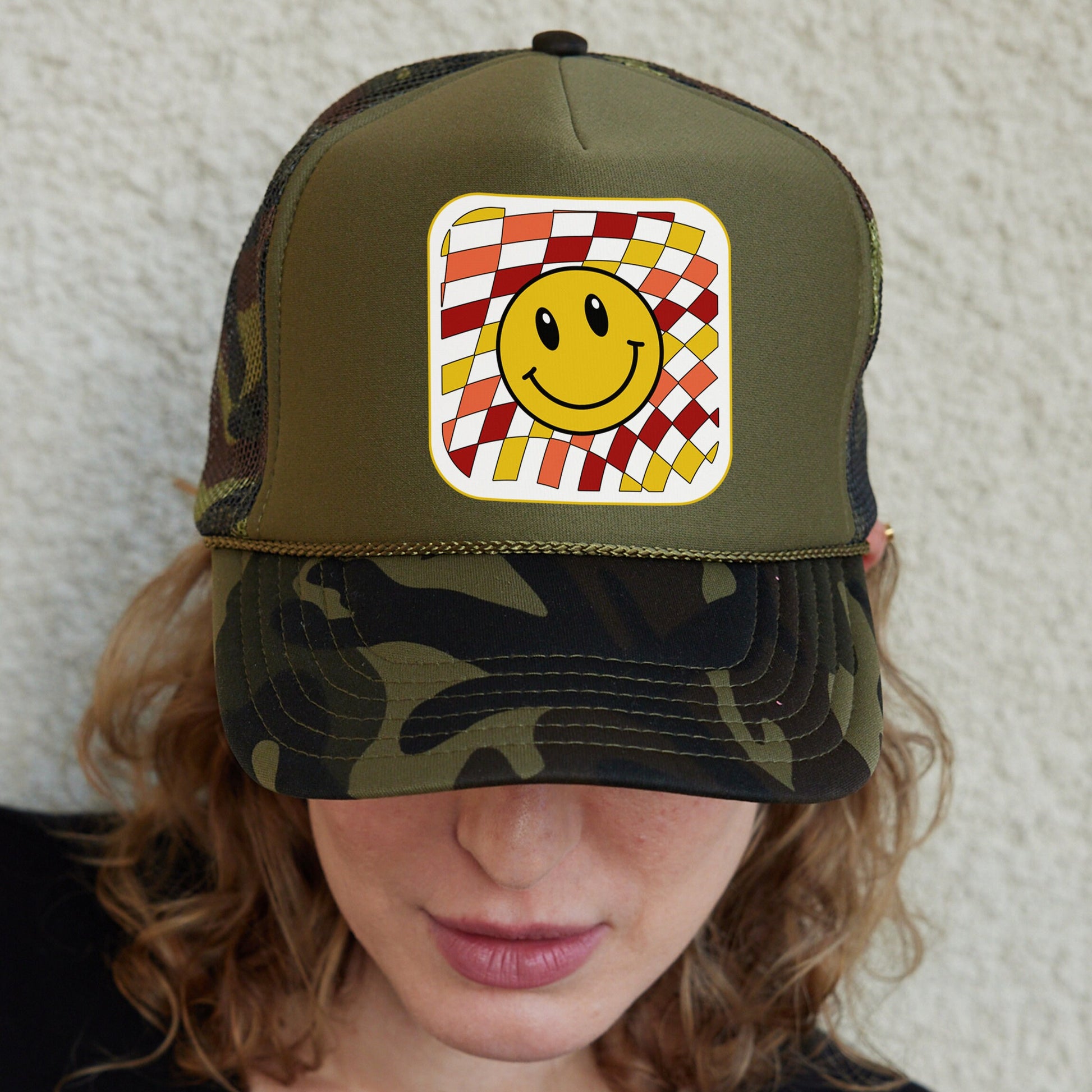 a woman wearing a hat with a smiley face on it