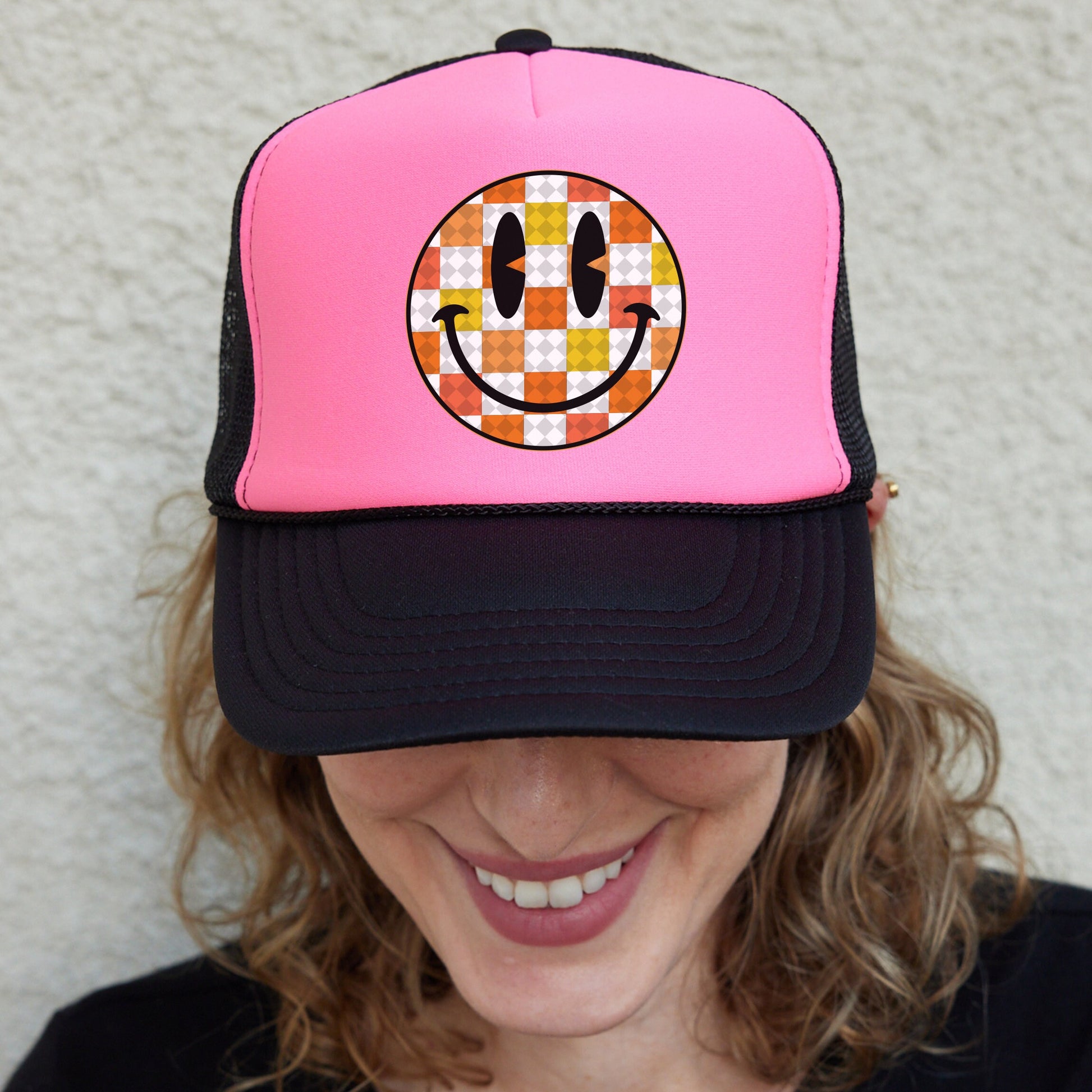 a woman wearing a pink hat with a smiley face on it