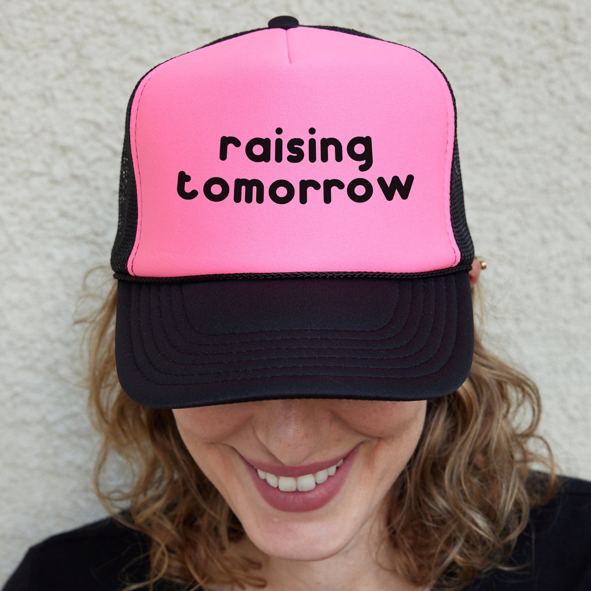 a woman wearing a pink and black trucker hat