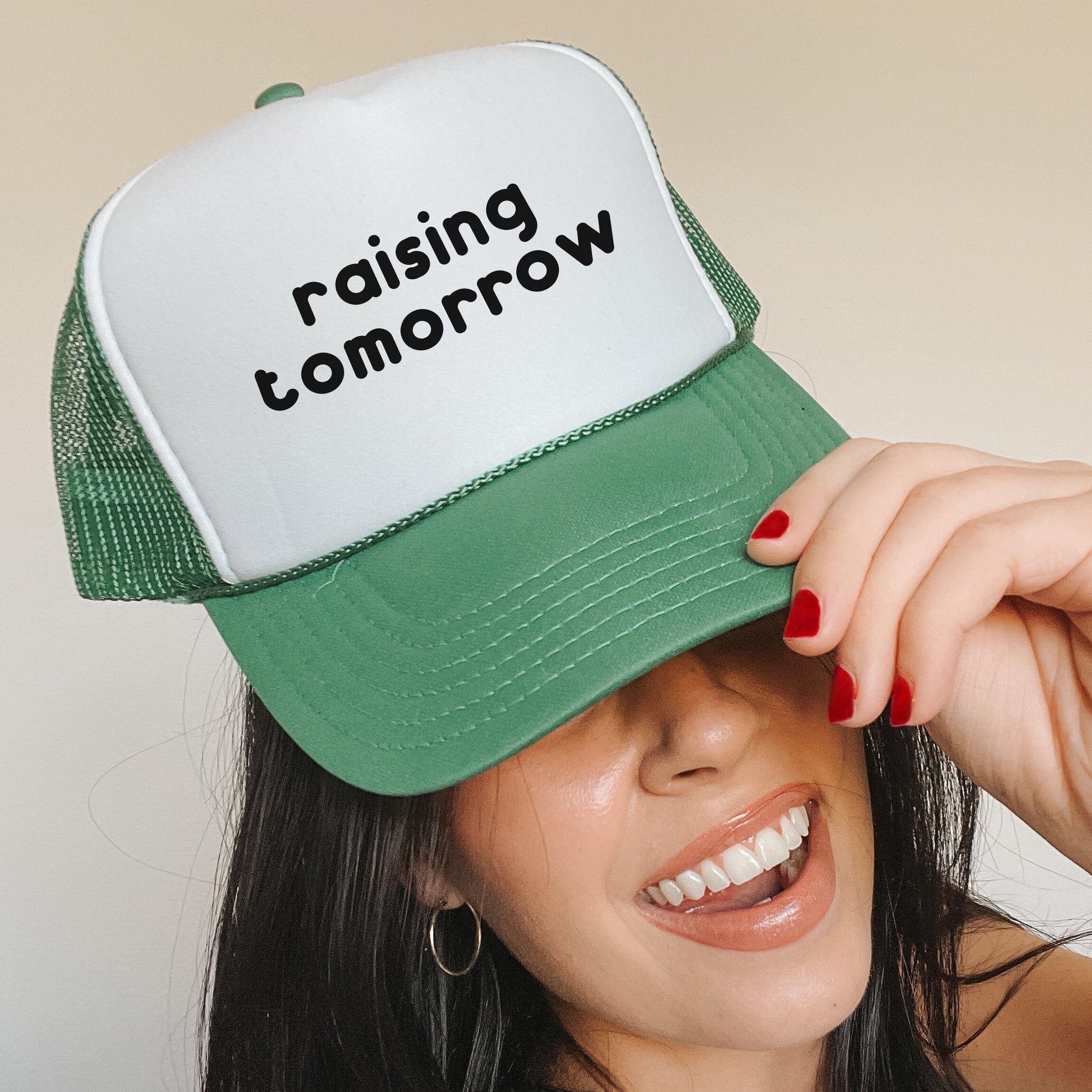 a woman wearing a green and white trucker hat