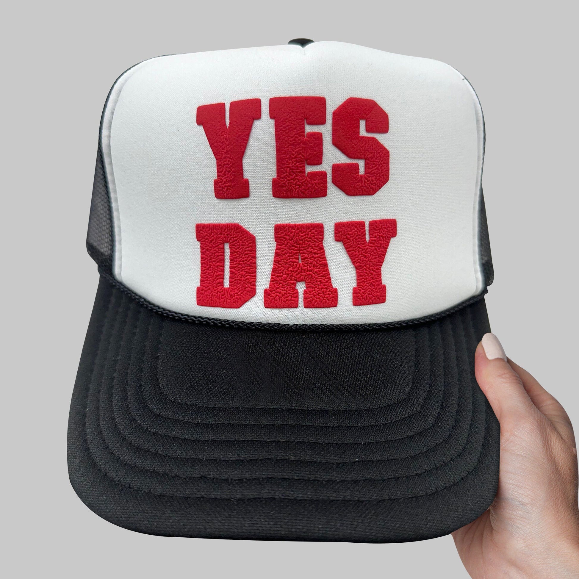 a person holding a hat with the words yes day on it