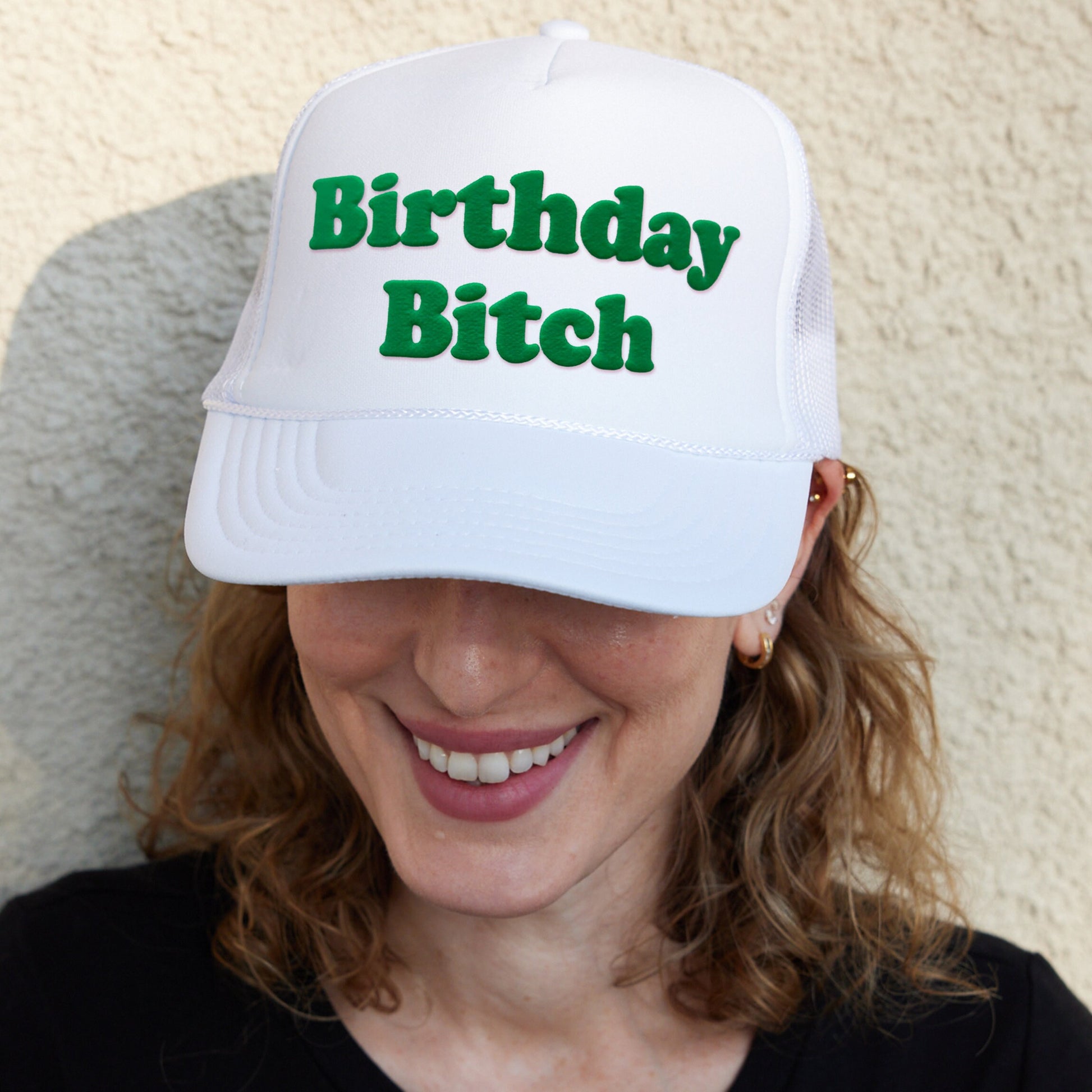 a woman wearing a white hat with the words birthday bitch on it