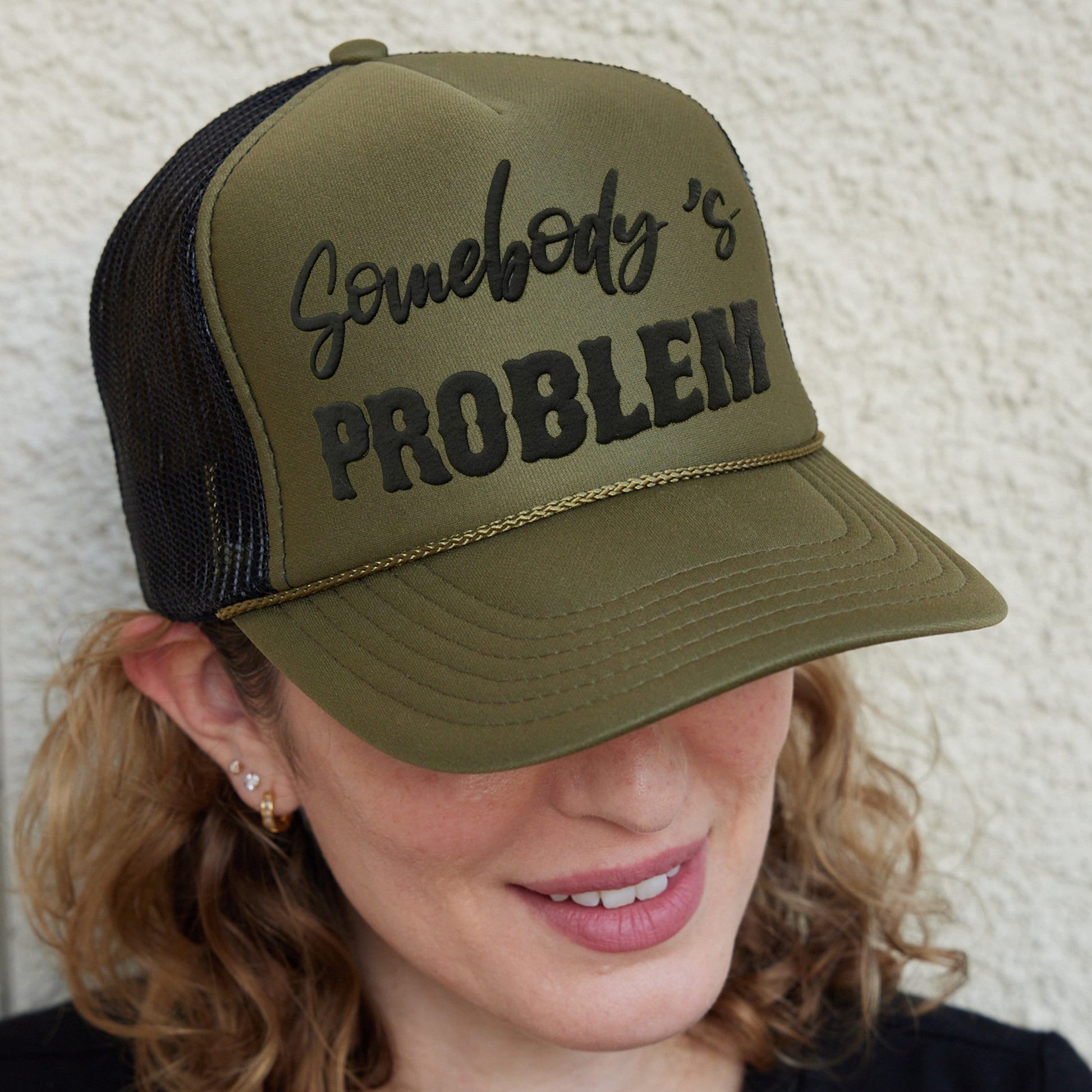 a woman wearing a trucker hat with the word gameboy&#39;s problem on