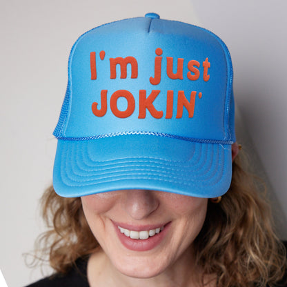 a woman wearing a blue hat that says i&#39;m just joking