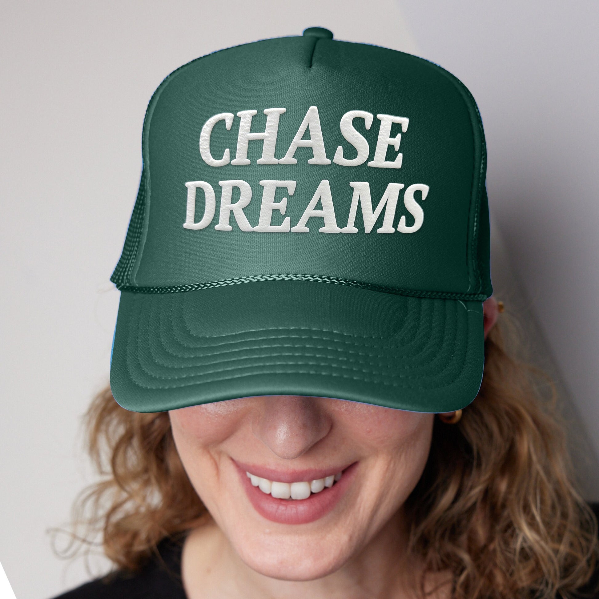 a woman wearing a green hat that says chase dreams