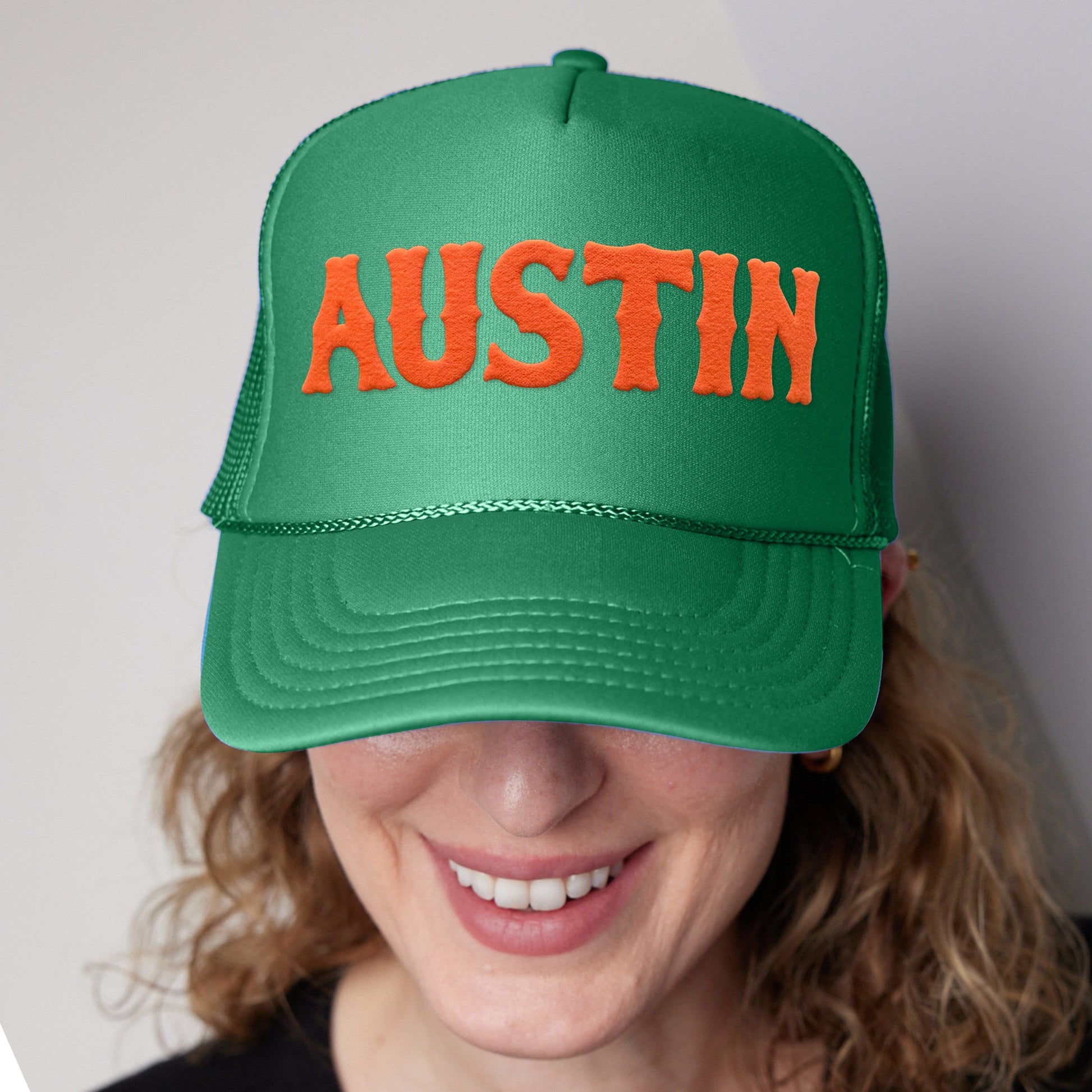 a woman wearing a green hat with the word autism on it