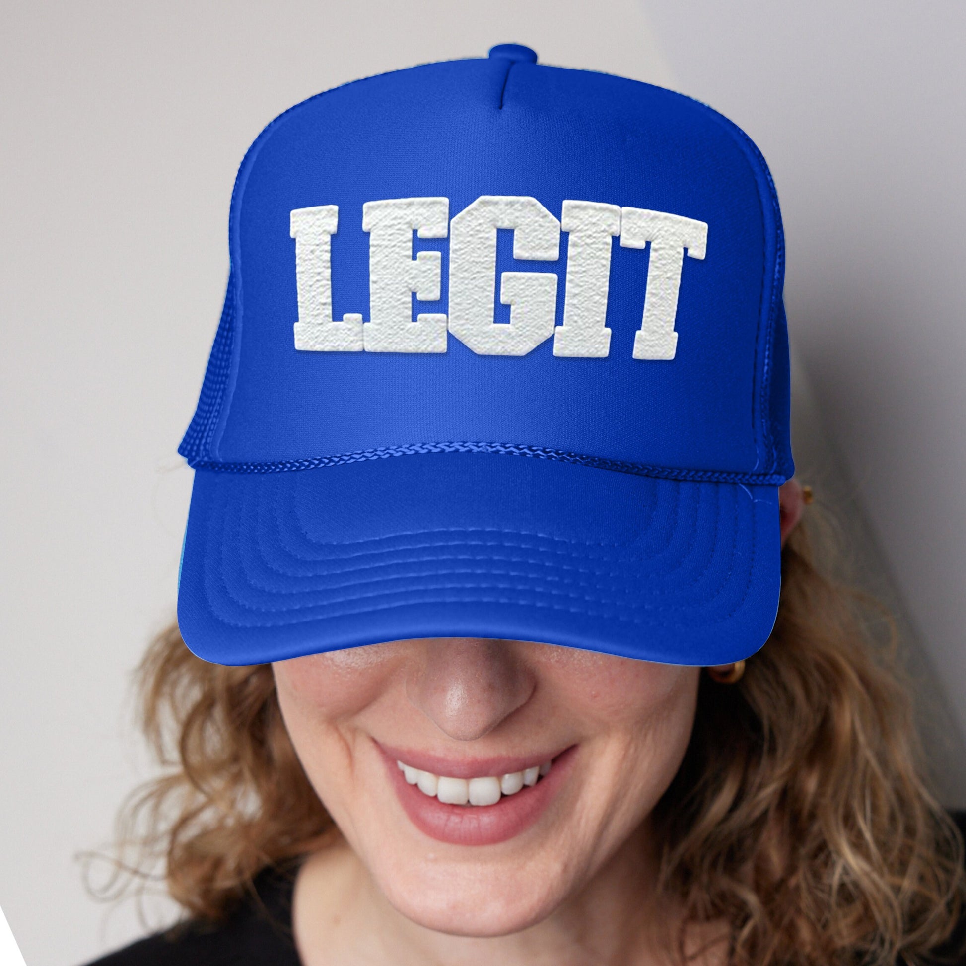 a woman wearing a blue hat with the word legit printed on it