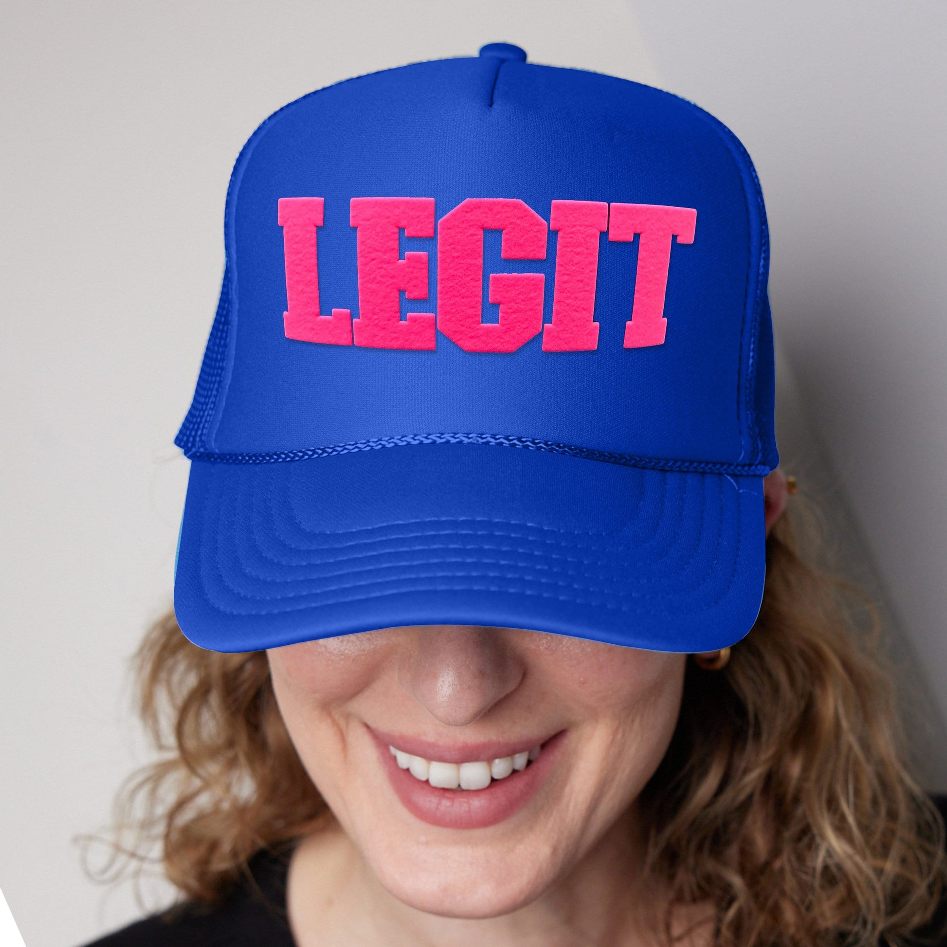 a woman wearing a blue hat with the word legit printed on it