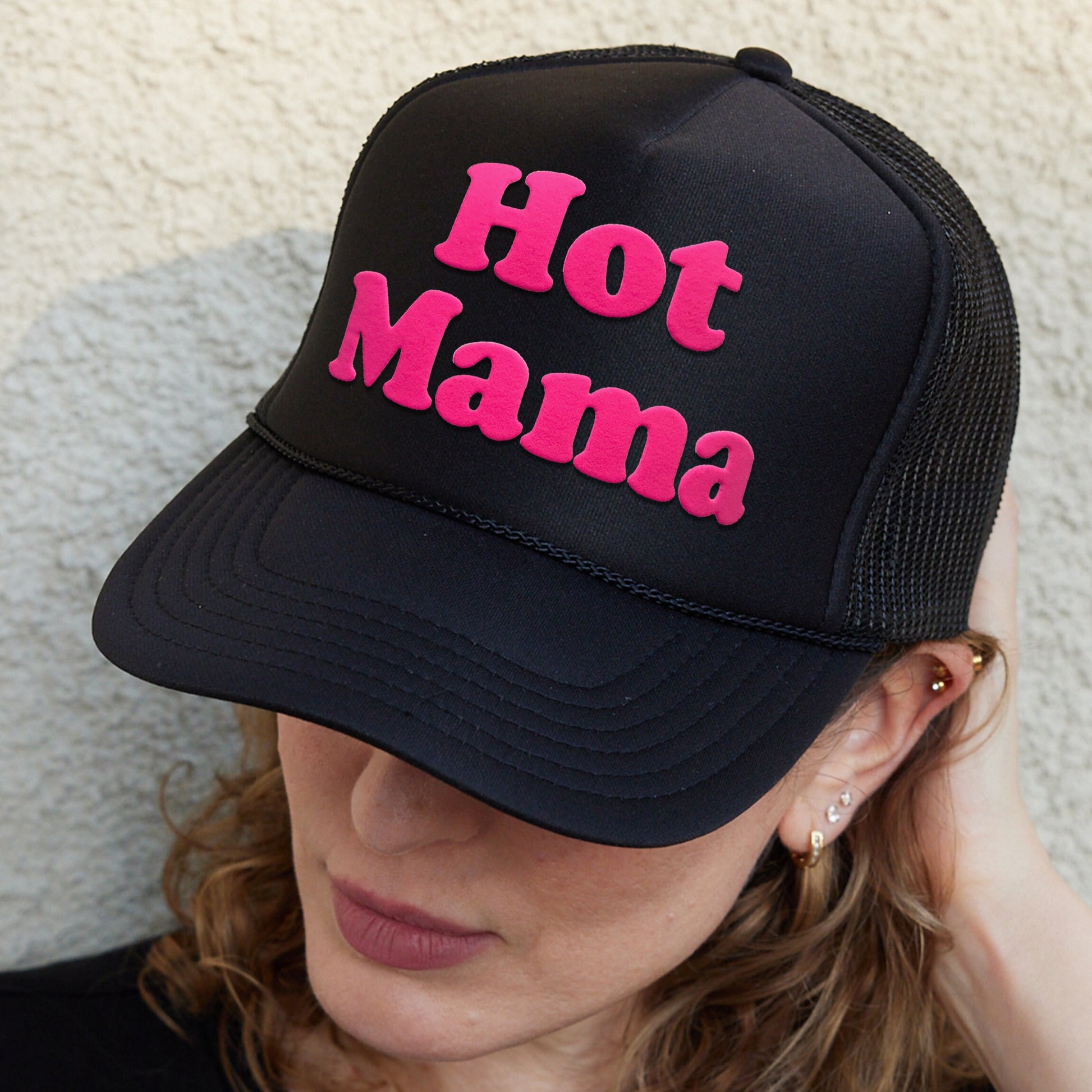 a woman wearing a black hat with hot mama on it