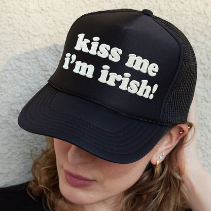 a woman wearing a black hat with the words kiss me i&#39;m irish on
