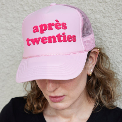 a woman wearing a pink hat that says apres twenty