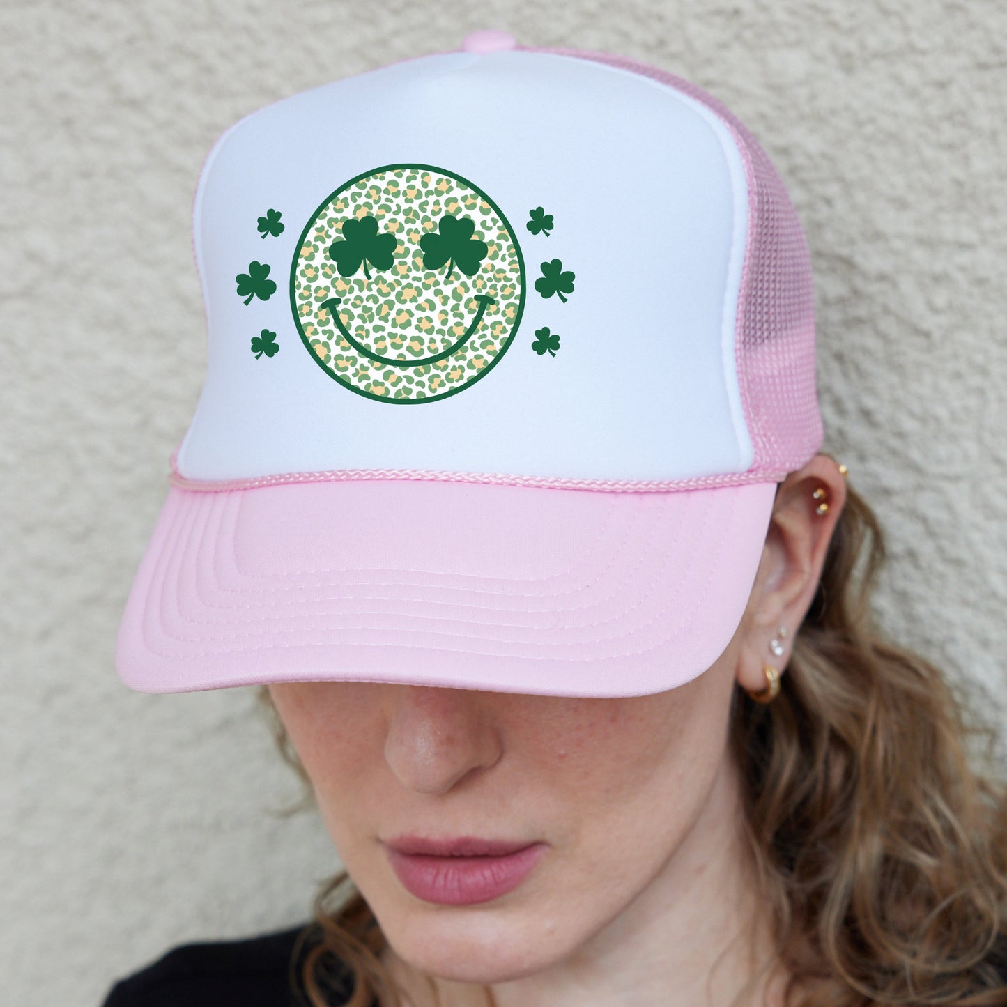 a woman wearing a pink and white hat with a smiling face