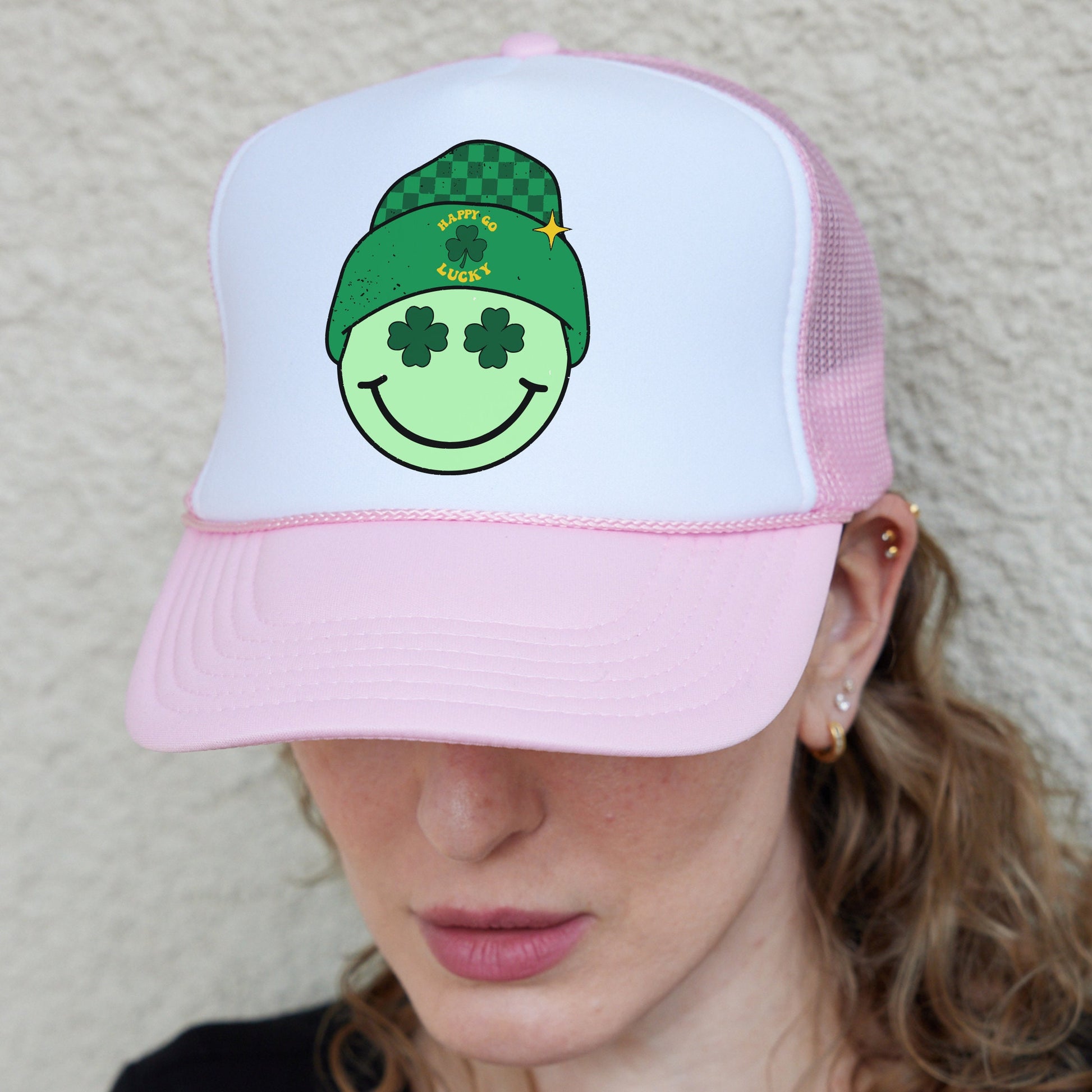 a woman wearing a pink and white hat with a smiling face on it