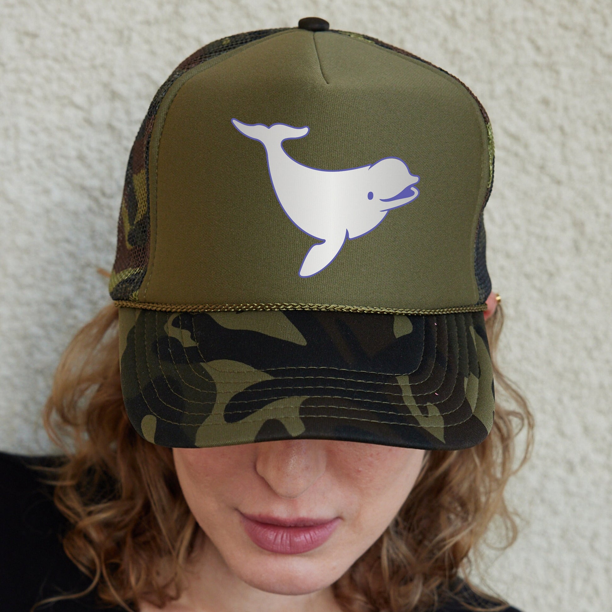 a woman wearing a hat with a dolphin on it