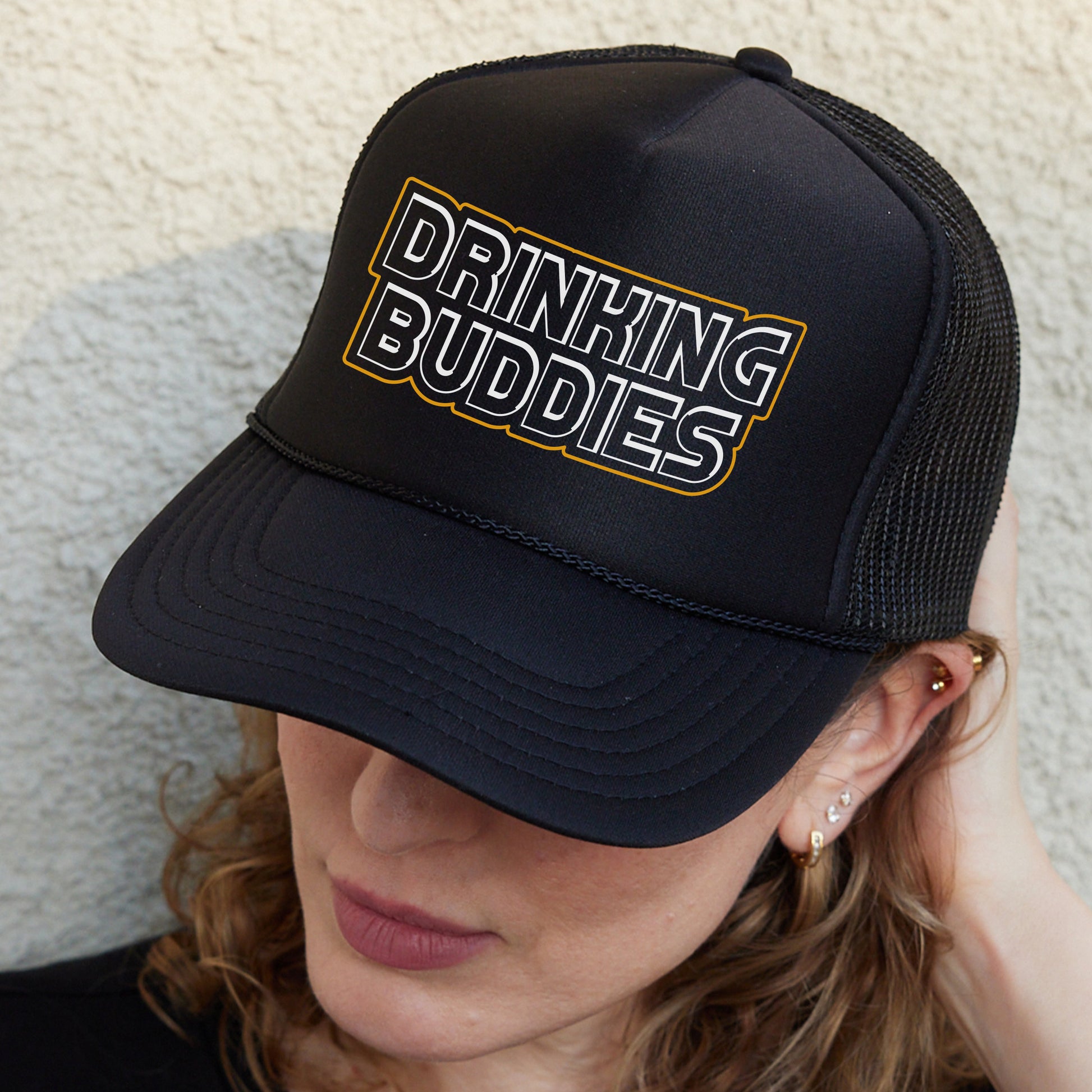 a woman wearing a black hat with the words drinking buddies on it