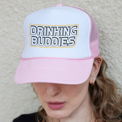 a woman wearing a pink and white hat with the words drinking buddies on it