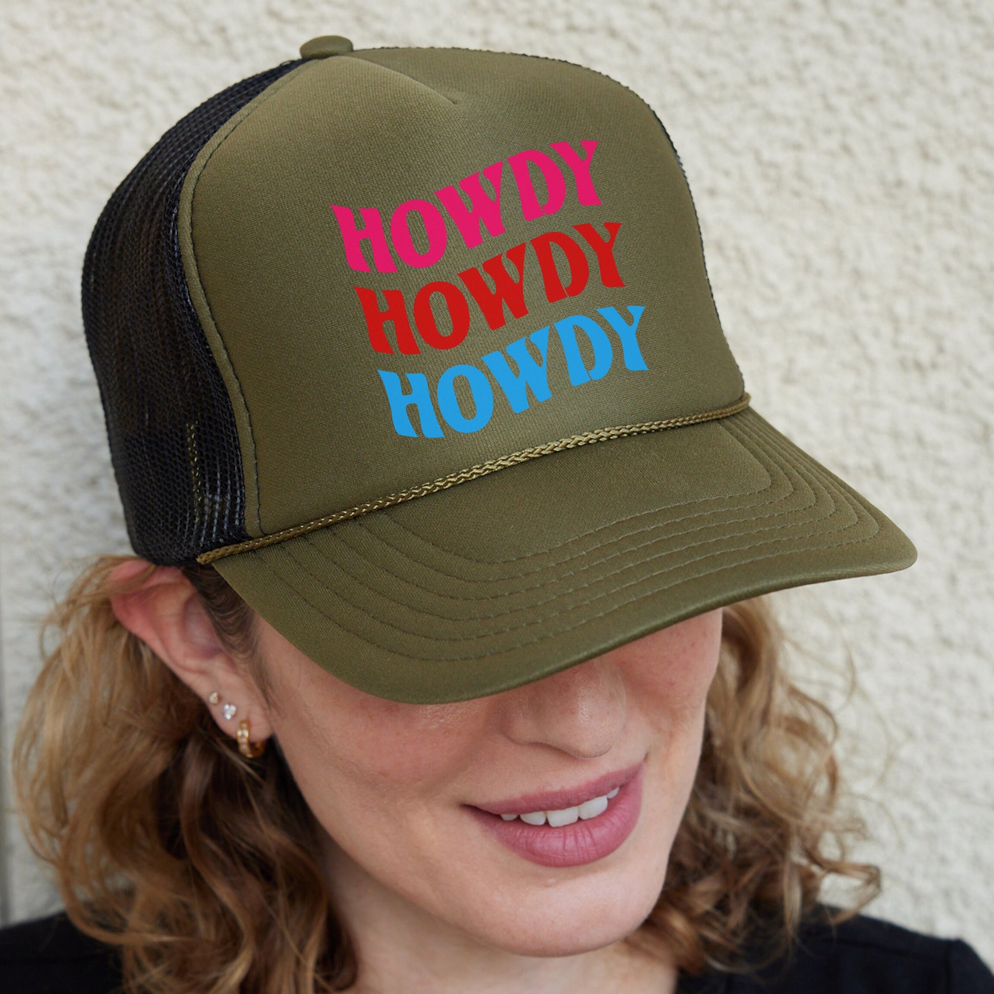 a woman wearing a trucker hat with the words hodgy howdy