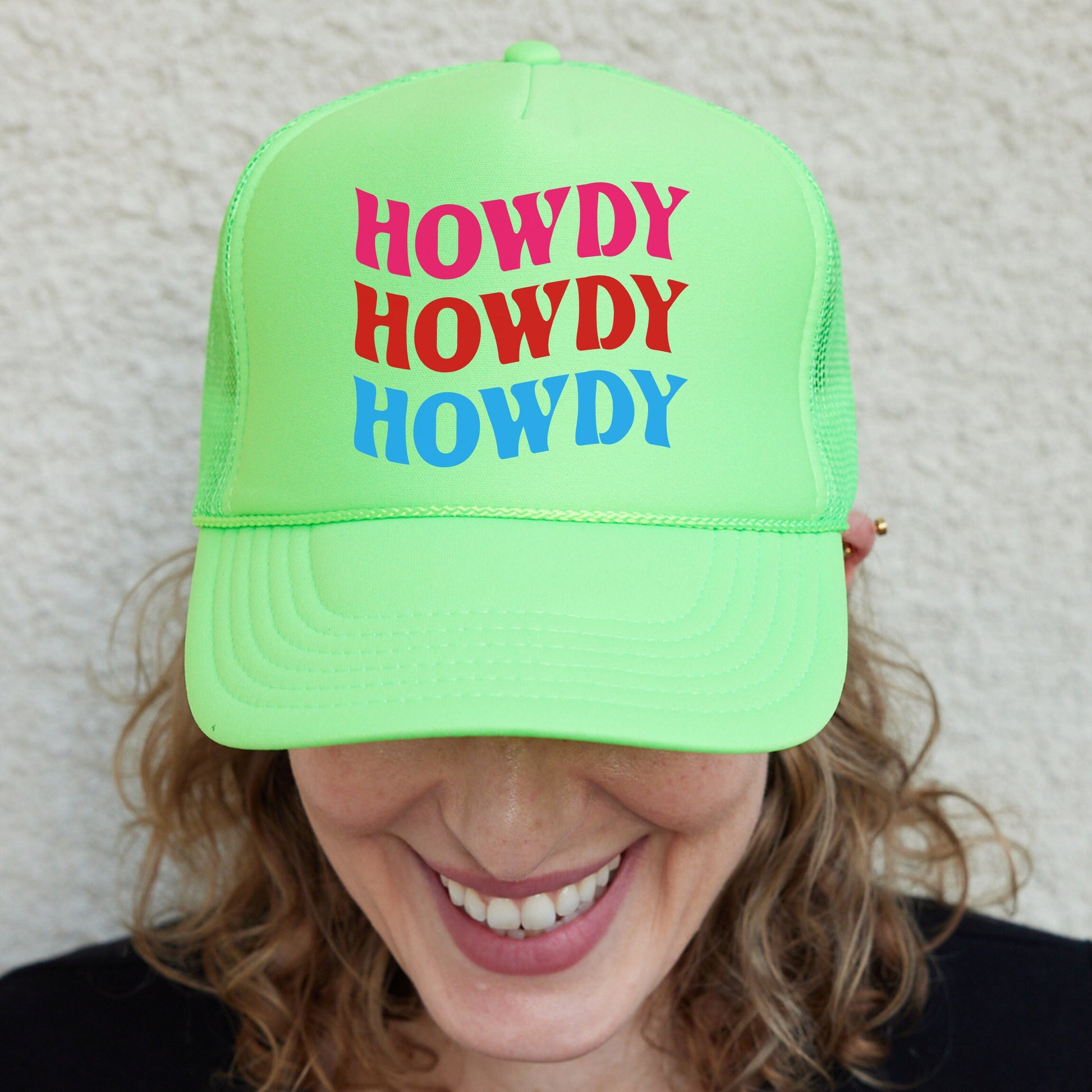 a smiling woman wearing a neon green hat
