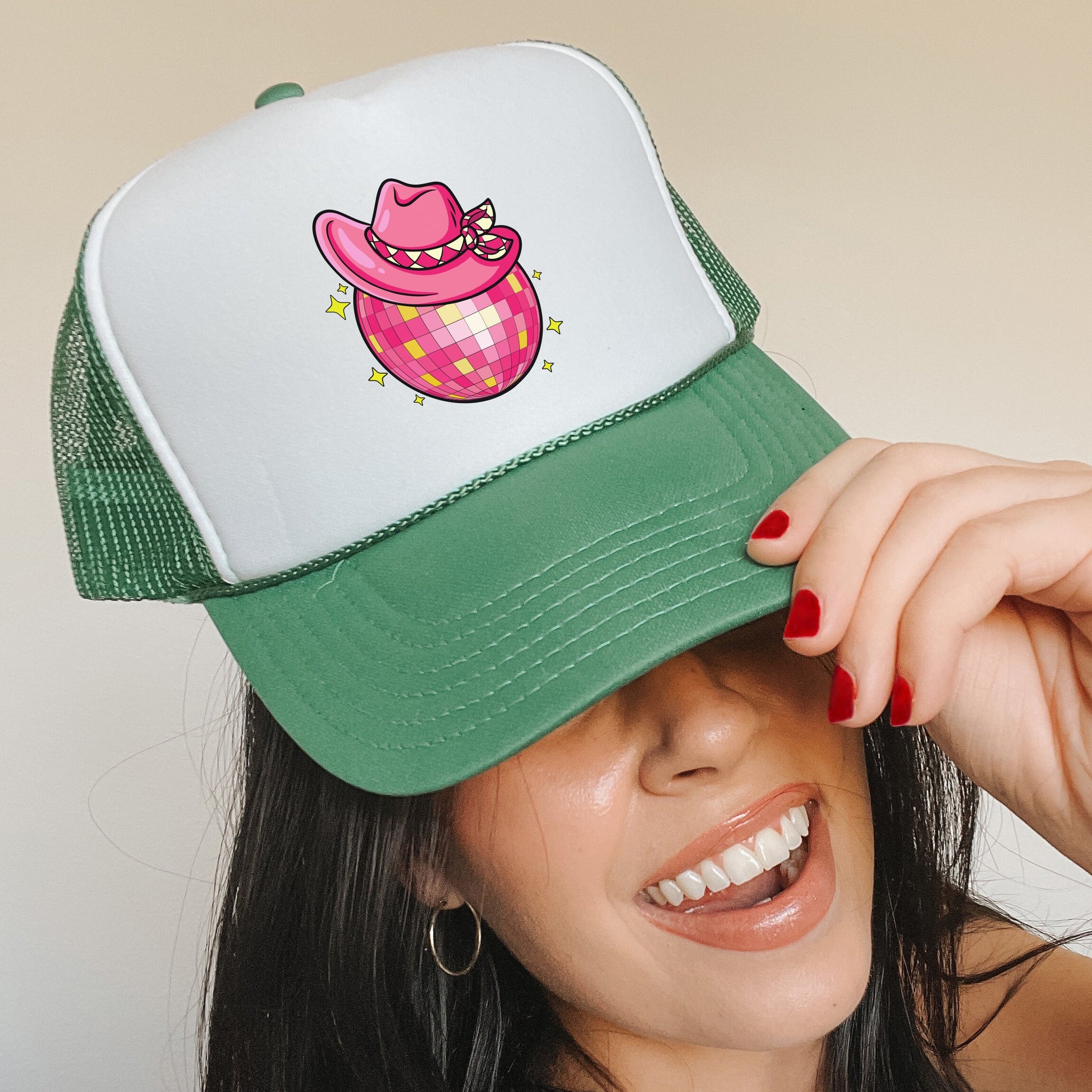 a woman wearing a green and white hat with a pink cow on it